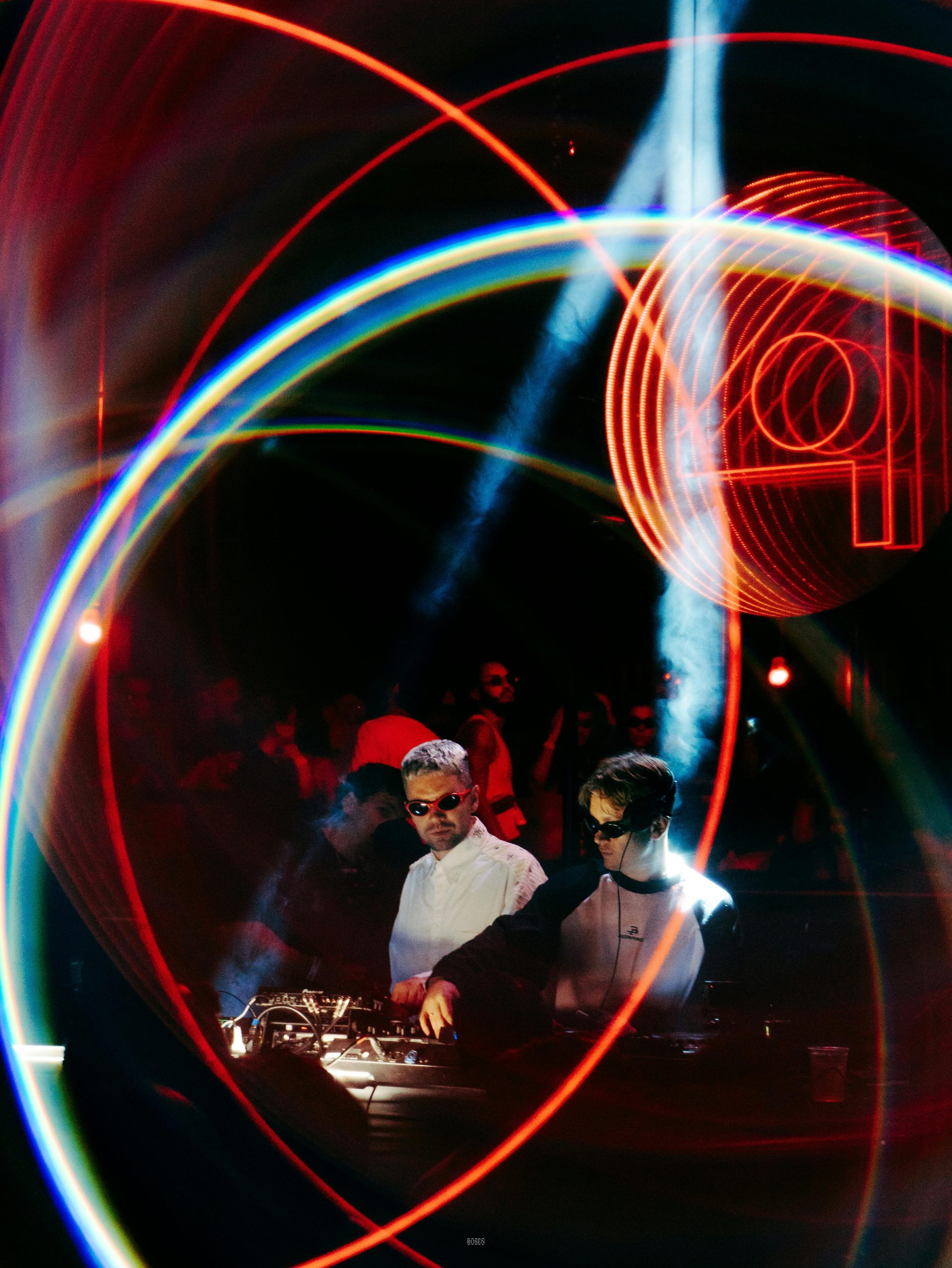 Vibrant nightclub scene with DJ and neon light streaks, capturing nightlife energy.